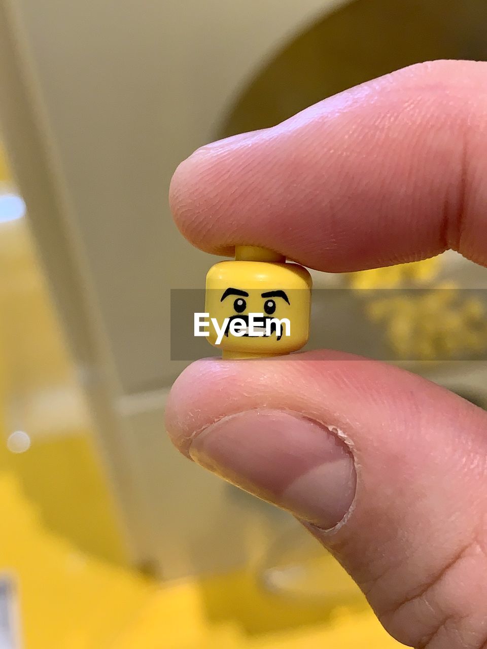 CLOSE-UP OF PERSON HAND HOLDING YELLOW PAPER