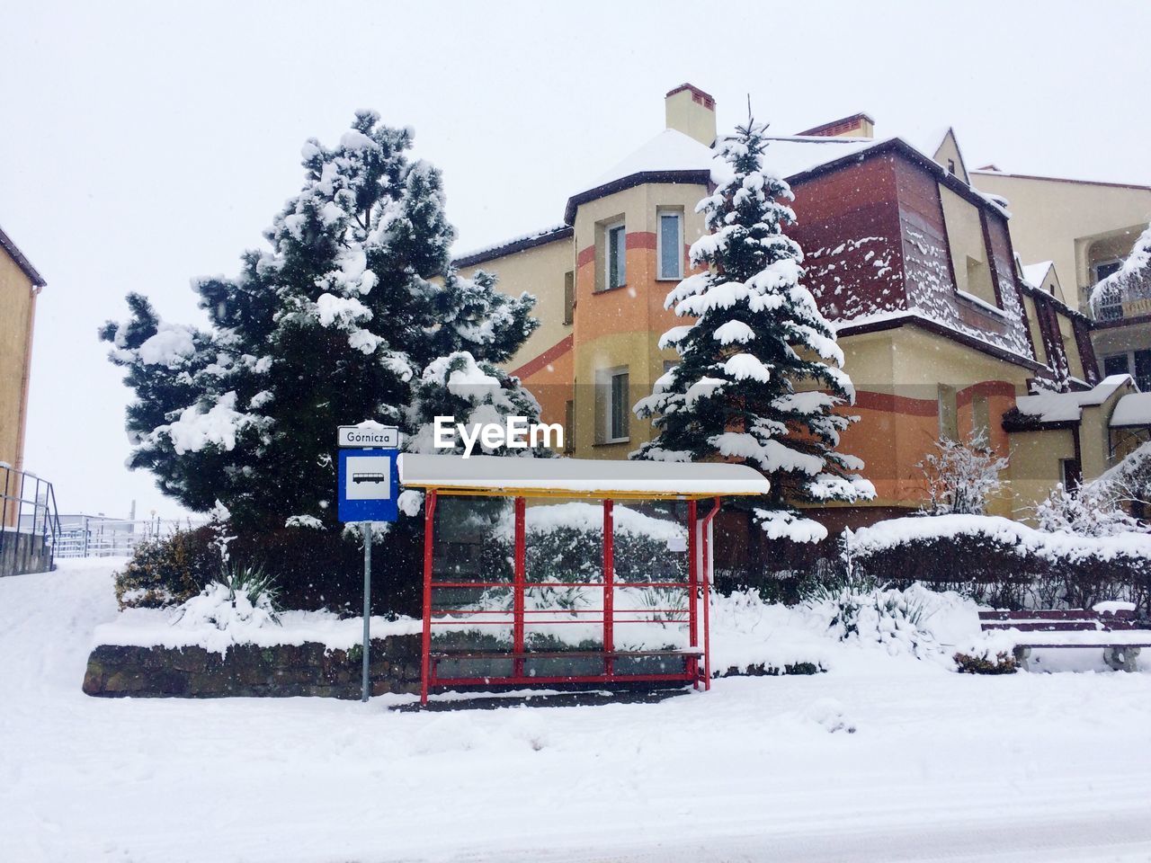 SNOW COVERED HOUSE AND BUILDING AGAINST SKY