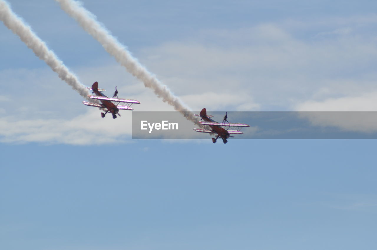 Low angle view of airshow against sky