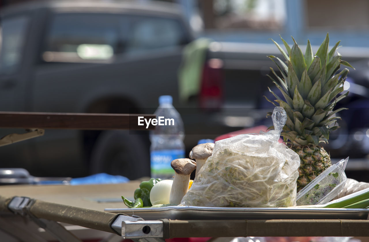 Various fruits and vegetables on table against pick-up truck