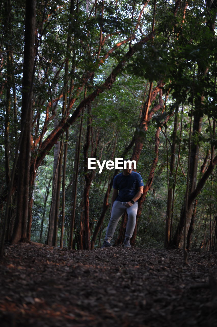 FULL LENGTH OF MAN WALKING ON TREE TRUNK