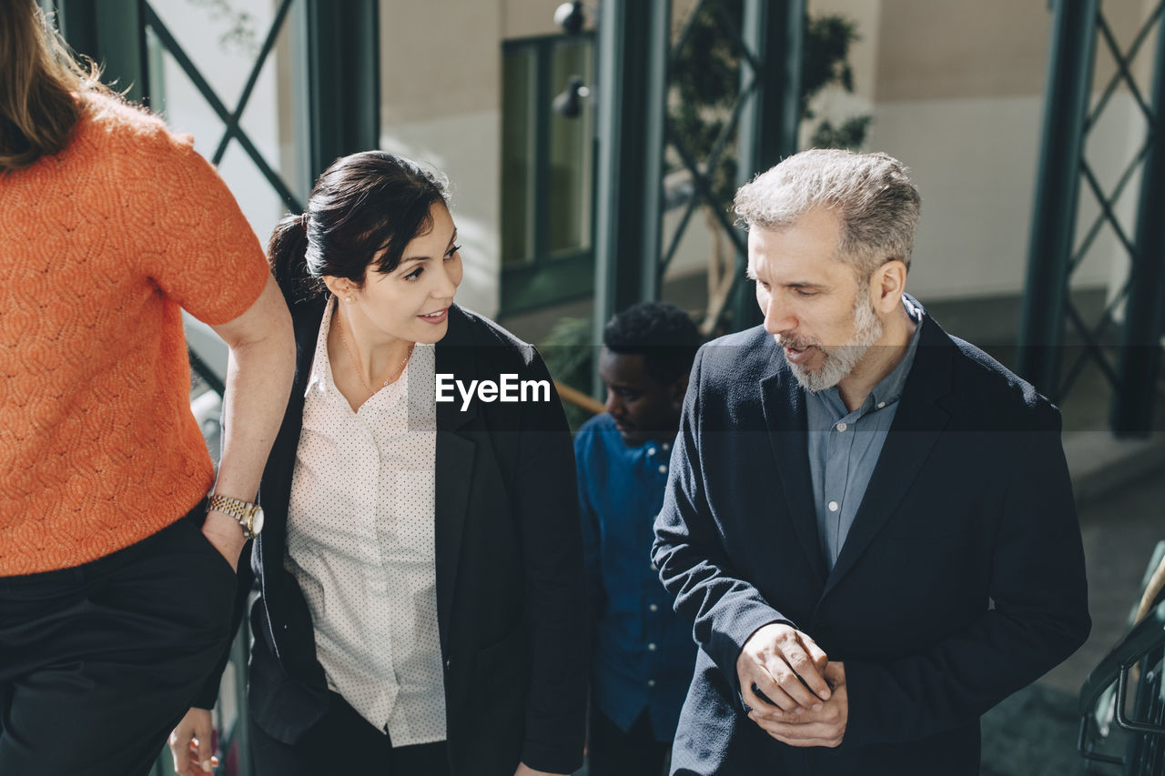 High angle view of business people talking while walking on steps