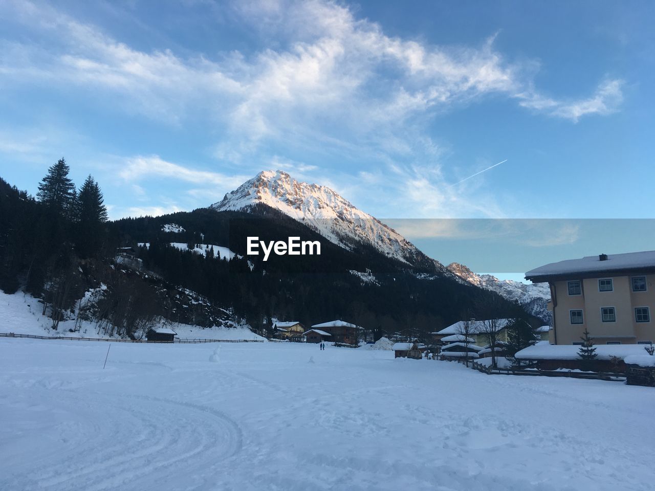 Houses on snowcapped mountain against sky