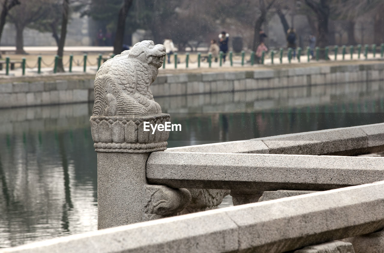 Close-up of statue on railing by river at gyeongbokgung