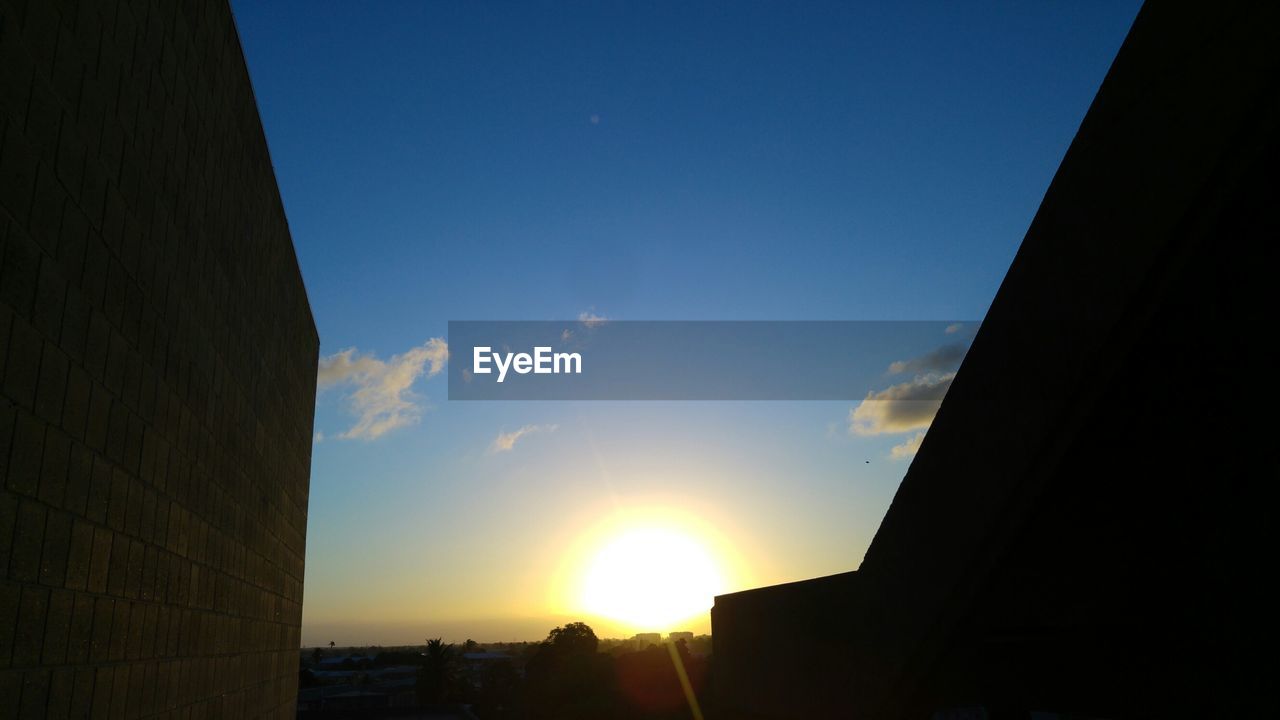 LOW ANGLE VIEW OF BUILDINGS AT SUNSET