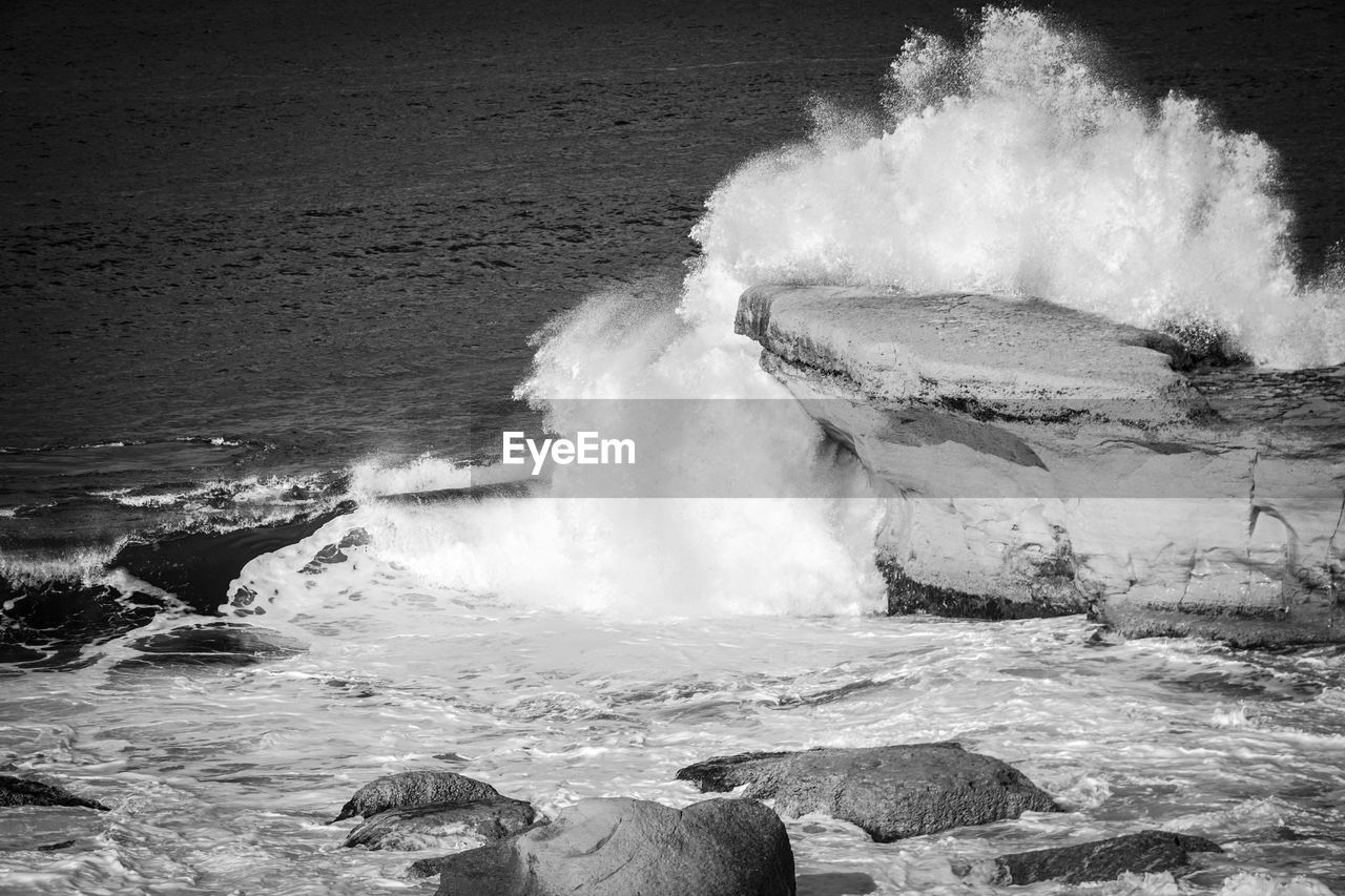 Waves splashing in sea against sky