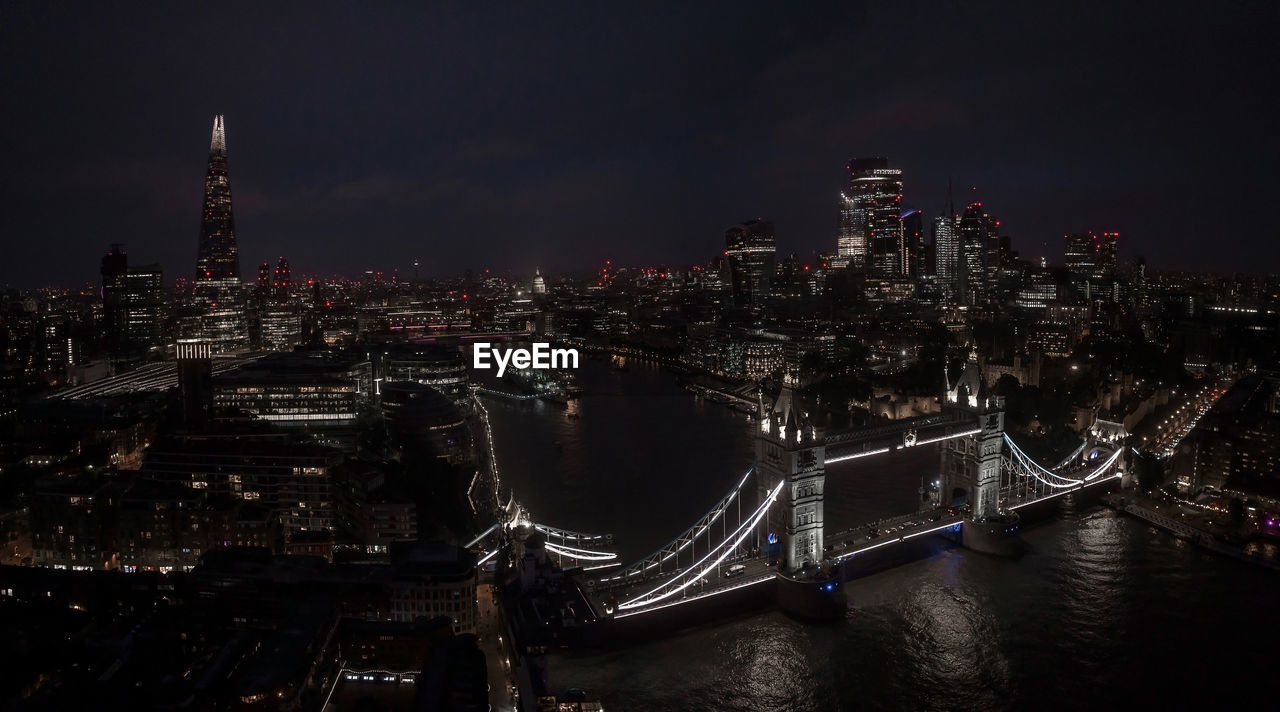 Aerial view to the illuminated tower bridge and skyline of london, uk