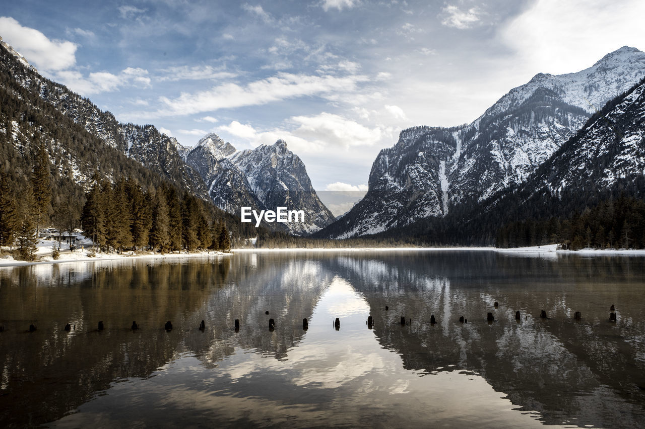 Scenic view of lake by snowcapped mountains against sky