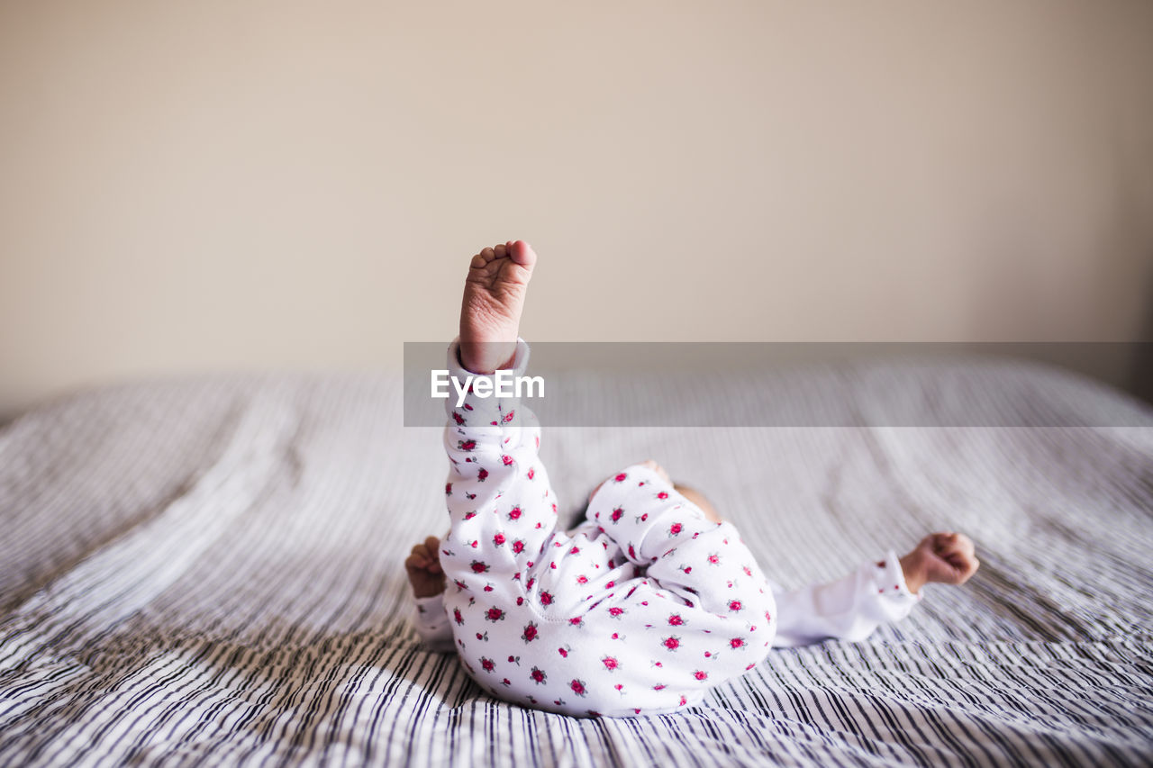 Close-up of baby boy on bed at home