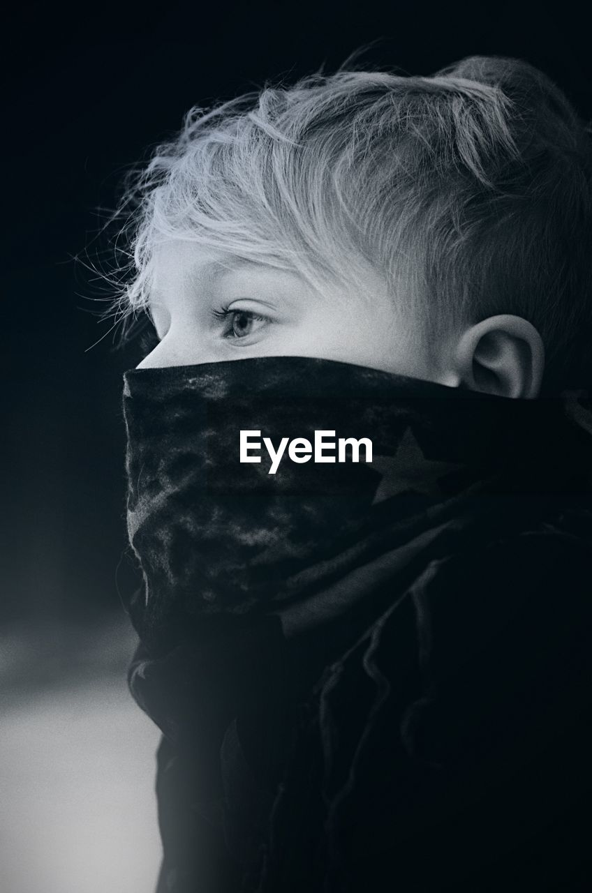 Close-up of boy covering face with scarf