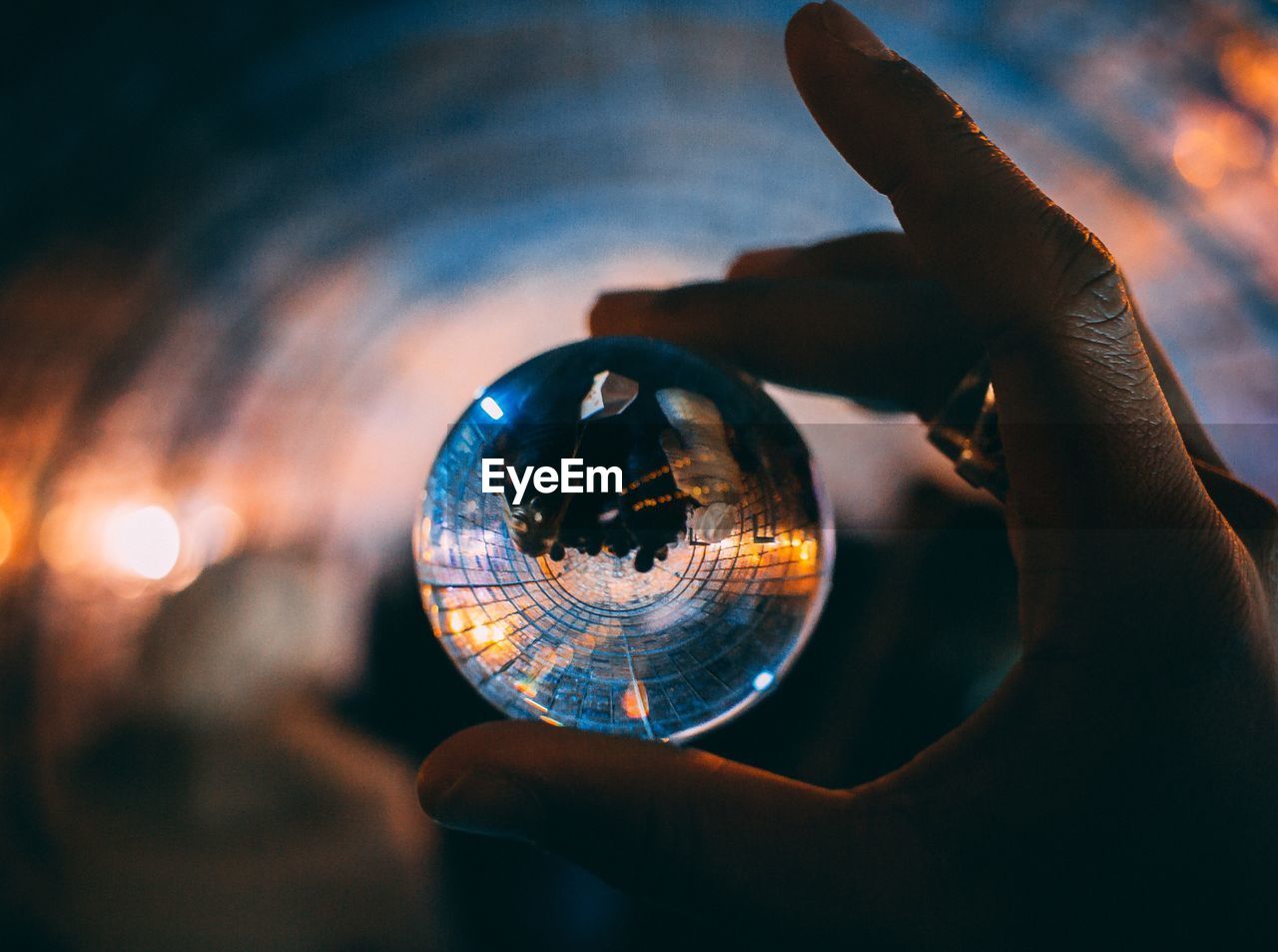 Close-up of human hand holding crystal ball during sunset