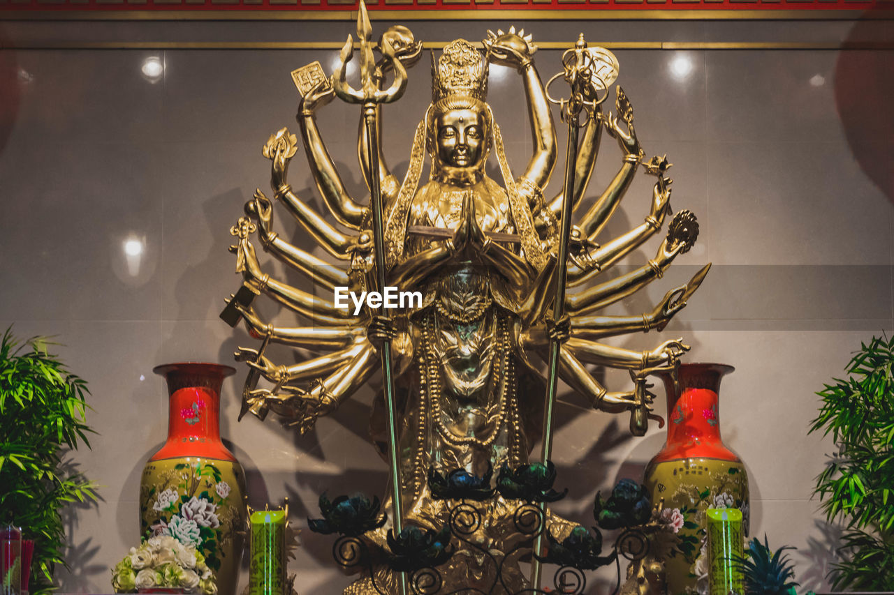 LOW ANGLE VIEW OF STATUE AGAINST ILLUMINATED TEMPLE