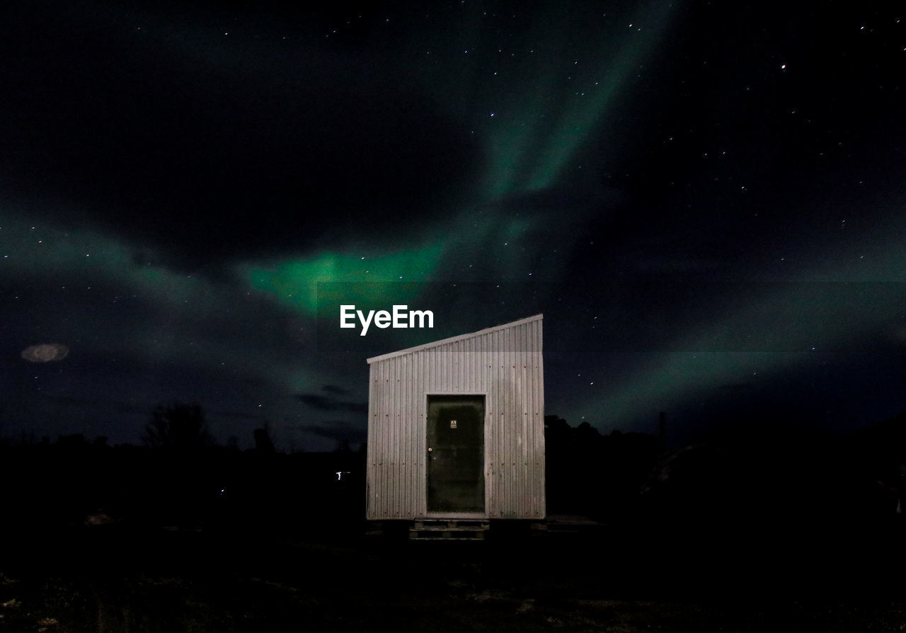 LOW ANGLE VIEW OF ILLUMINATED BUILDING AT NIGHT