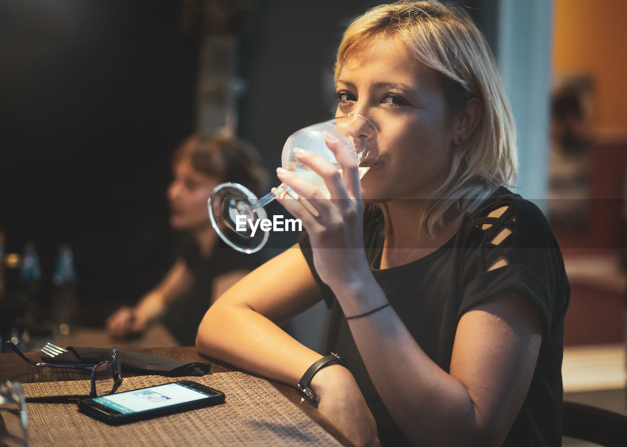 Portrait of woman drinking wine at restaurant