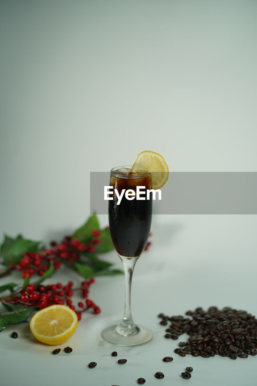 Close-up of drink on table against white background