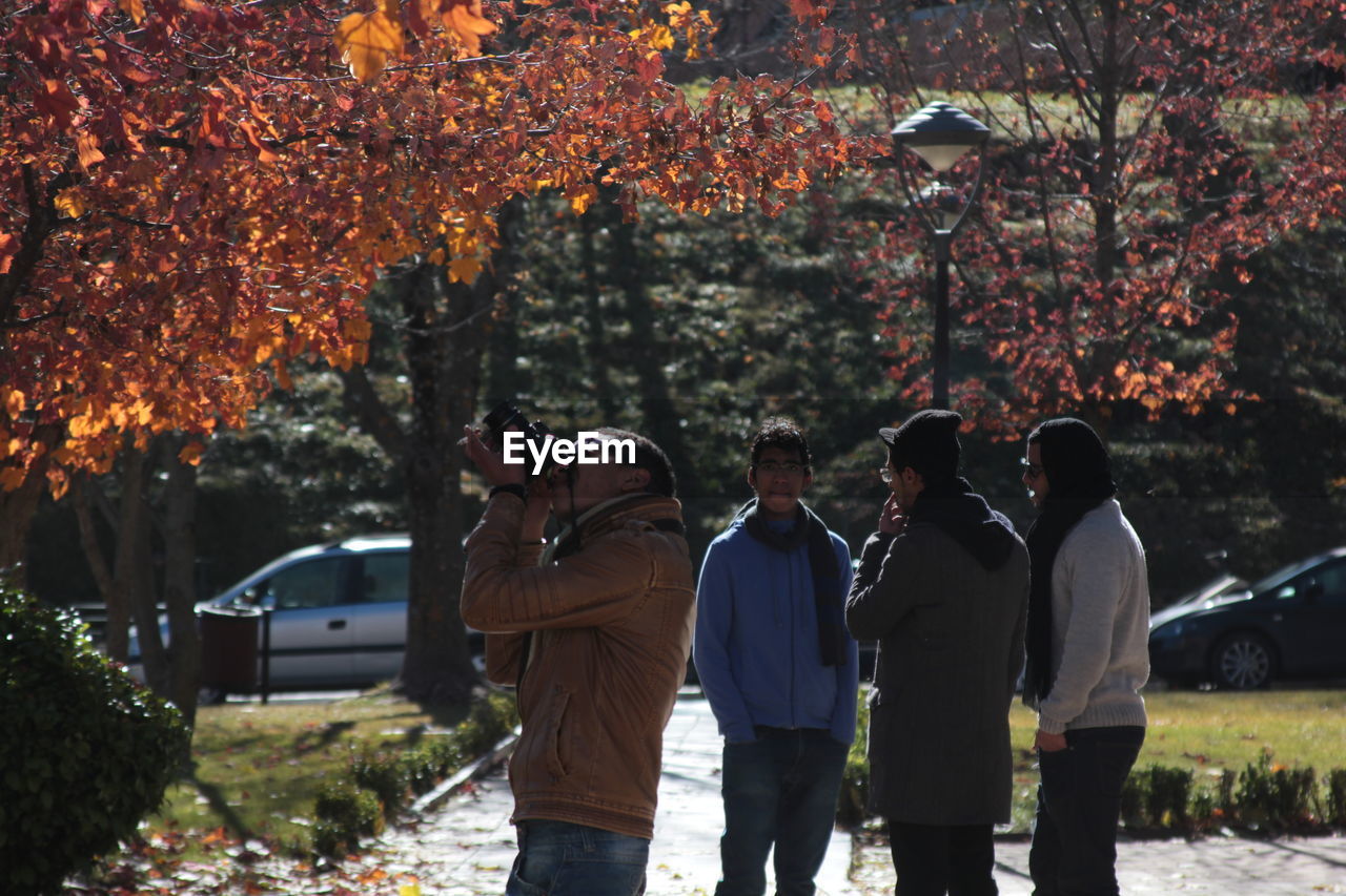 REAR VIEW OF PEOPLE PHOTOGRAPHING PLANTS