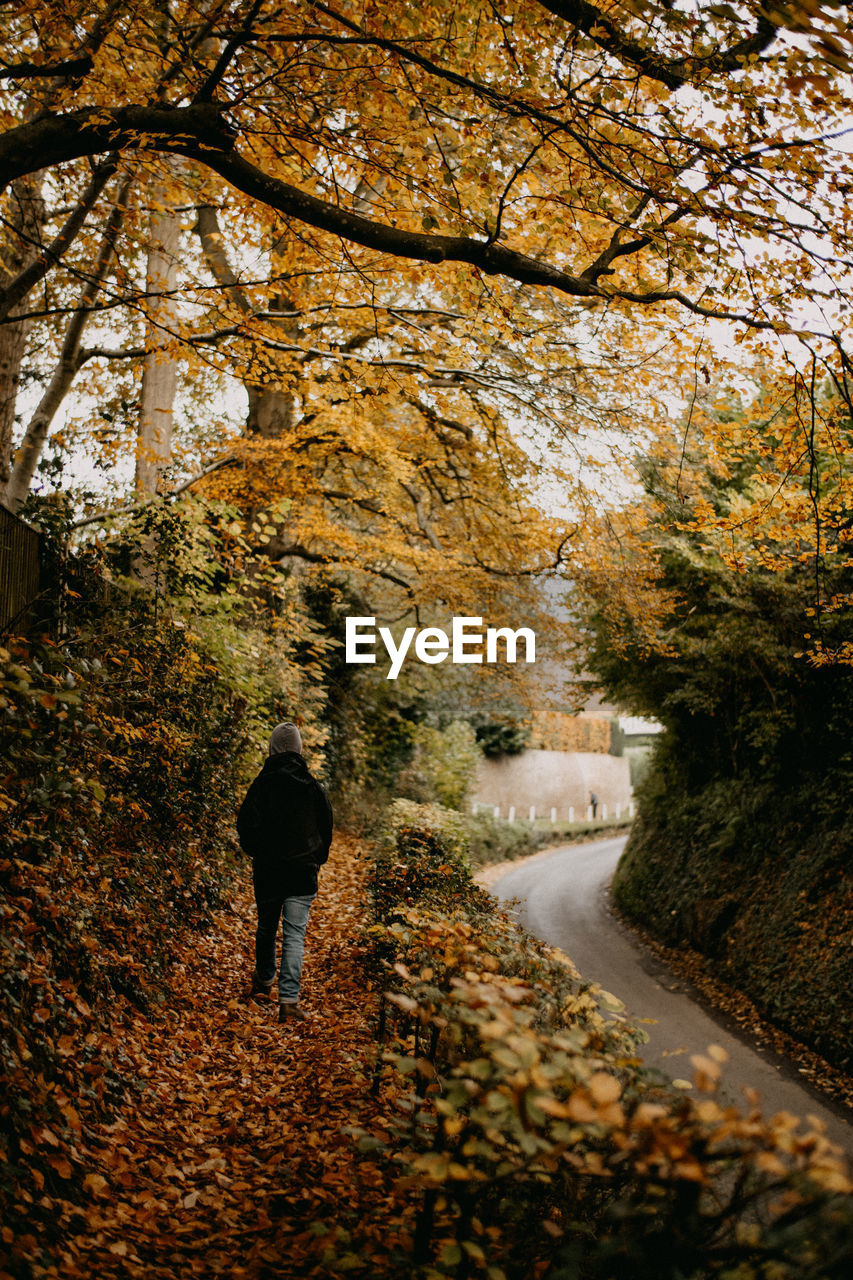 REAR VIEW OF TWO PEOPLE WALKING ON FOOTPATH