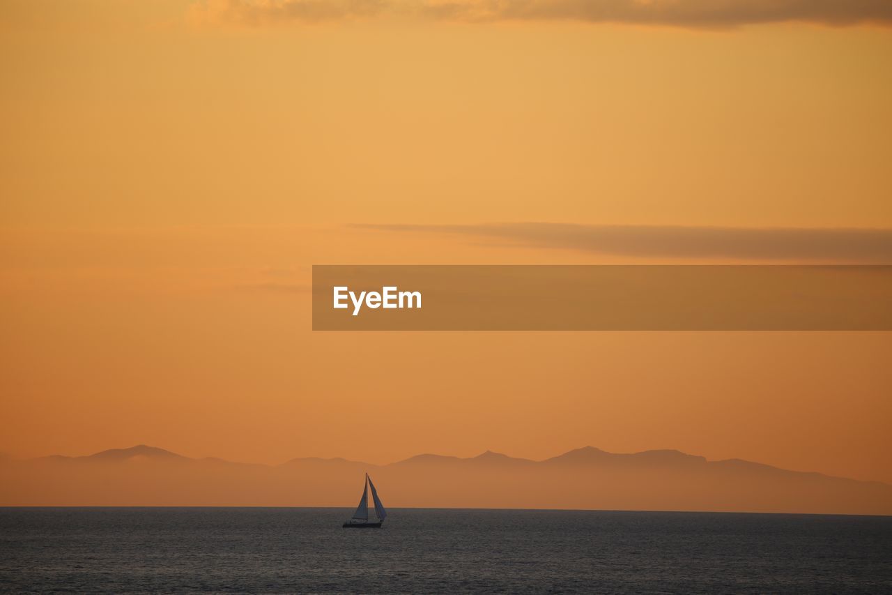 Scenic view of sea against orange sky