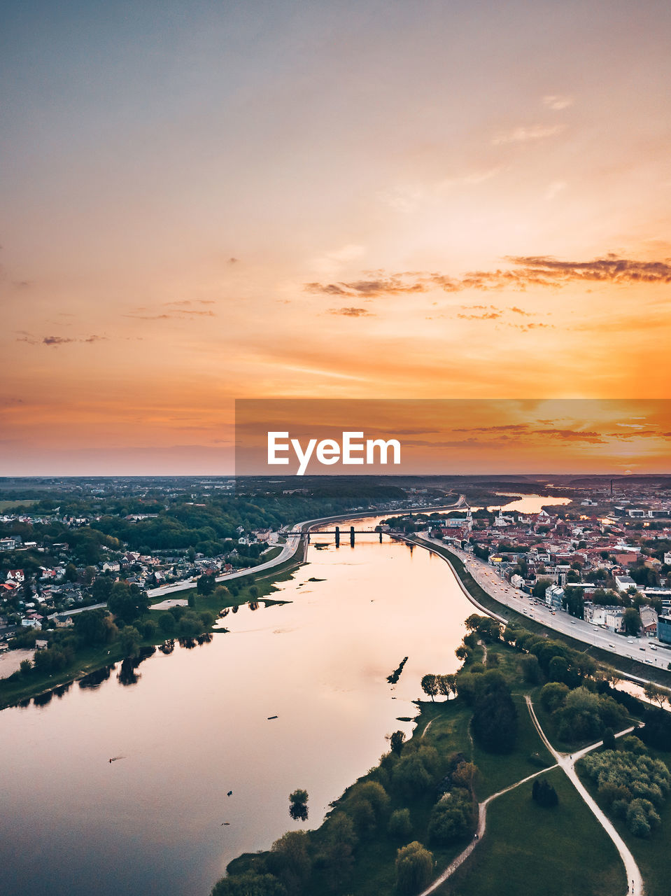 Aerial view of river in city against orange sky
