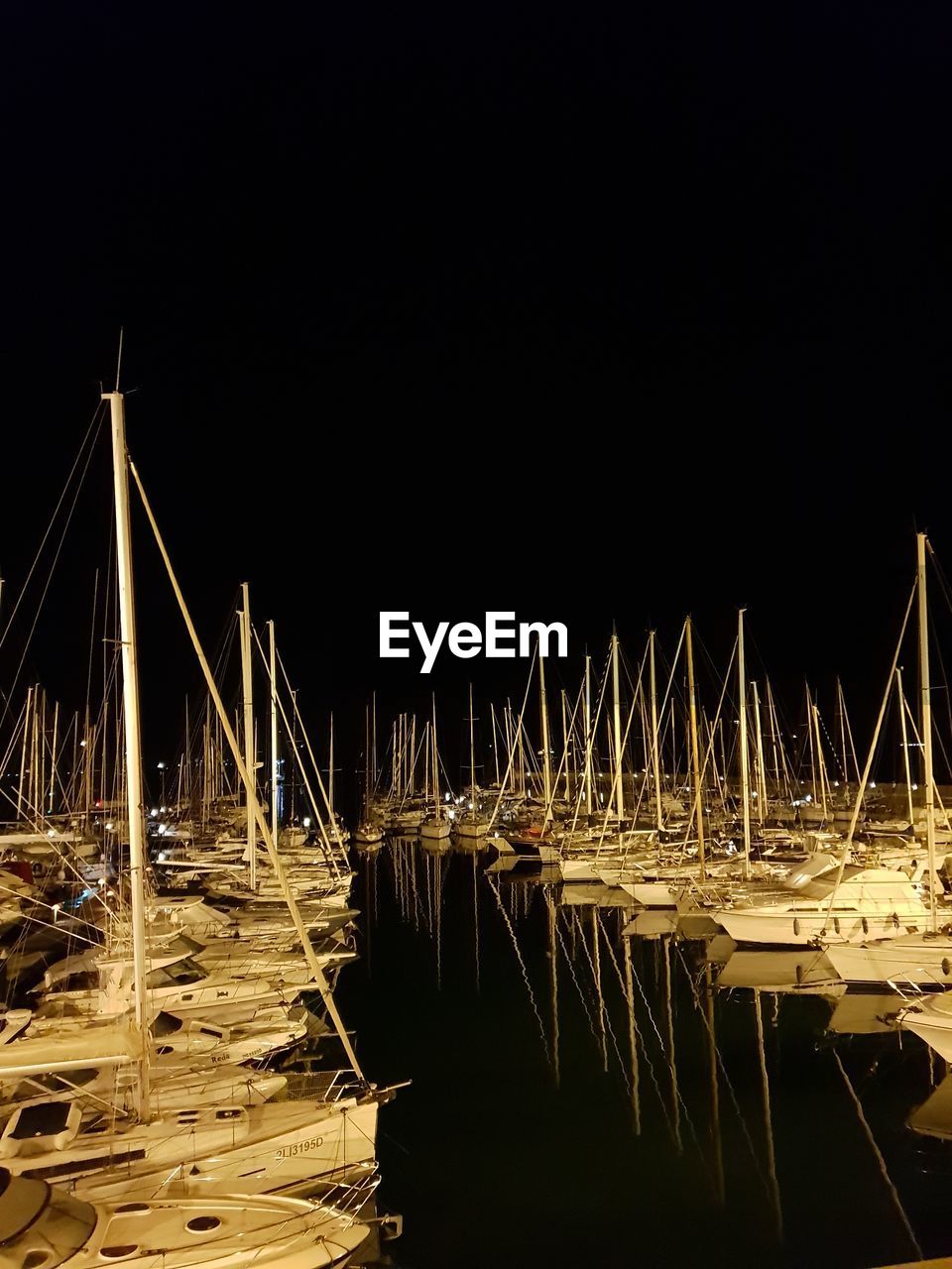 SAILBOATS MOORED AT HARBOR