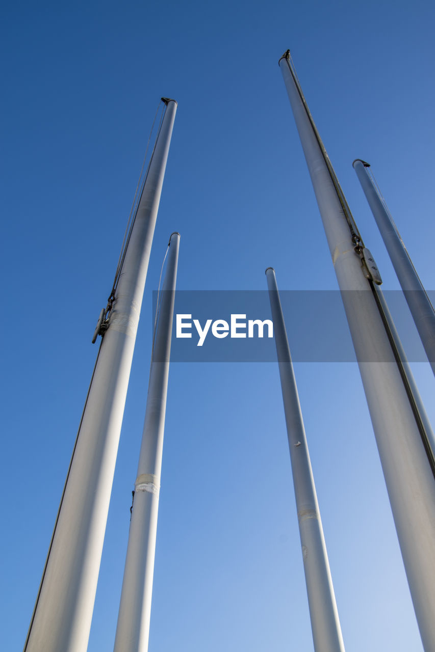 LOW ANGLE VIEW OF POLES AGAINST CLEAR BLUE SKY