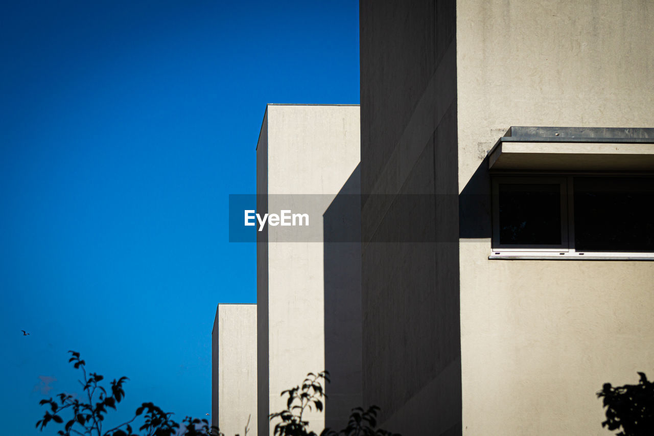 LOW ANGLE VIEW OF BLUE BUILDING AGAINST SKY