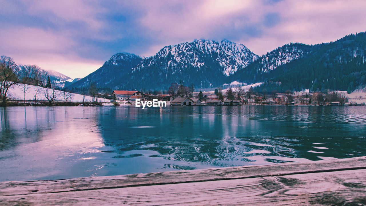 Scenic view of lake by snowcapped mountains against sky