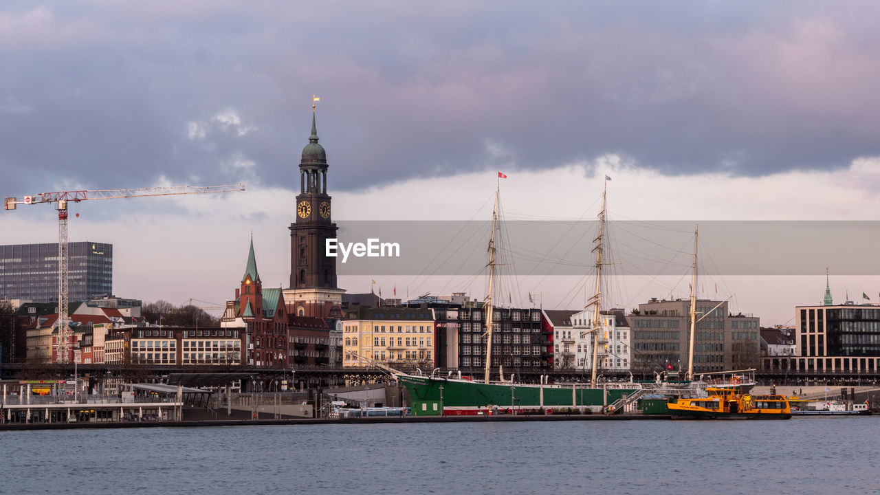 SAILBOATS IN SEA AGAINST BUILDINGS