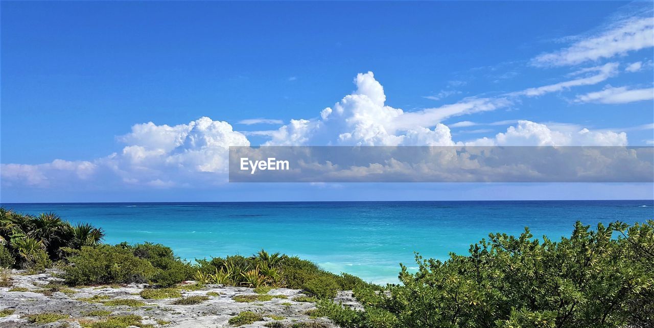 Scenic view of blue sea against blue sky with majestic clouds 