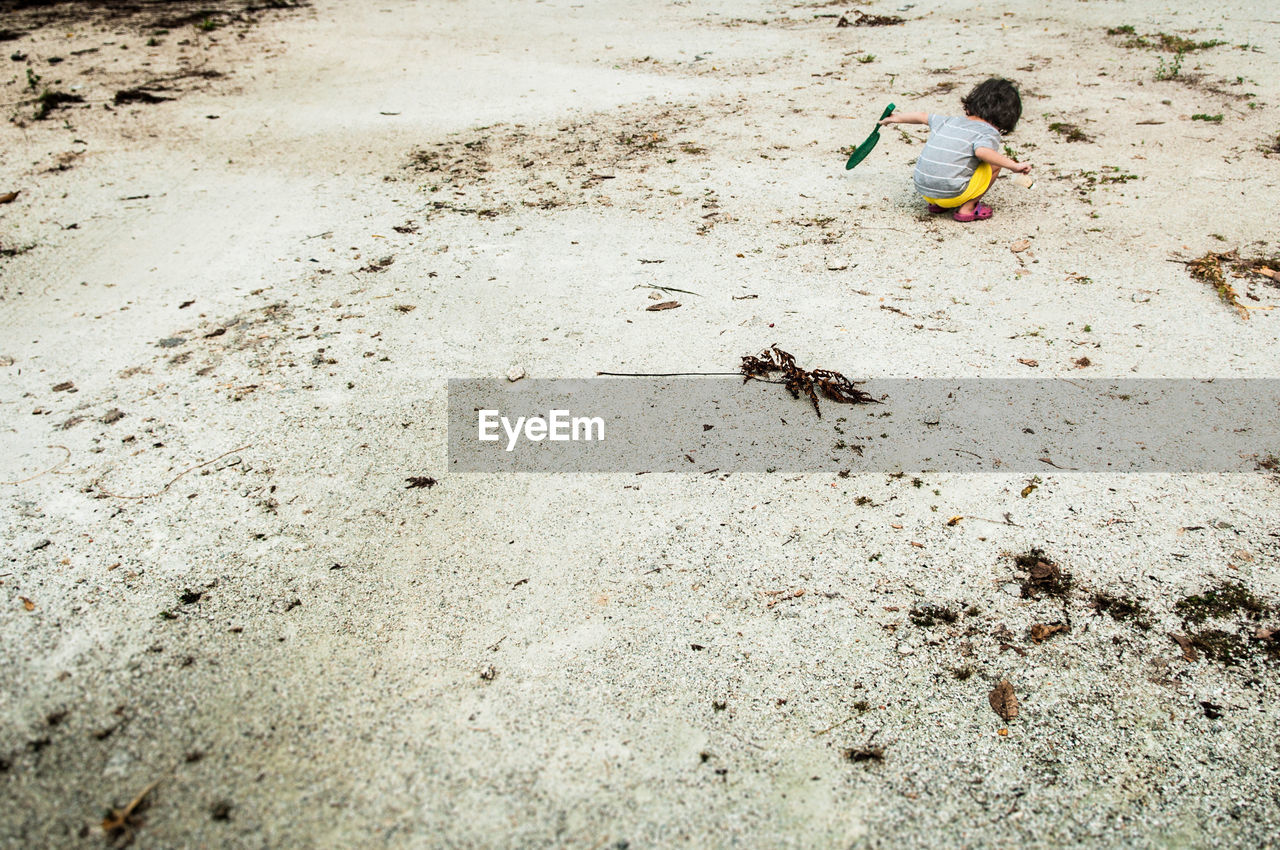 High angle view of child playing on sand