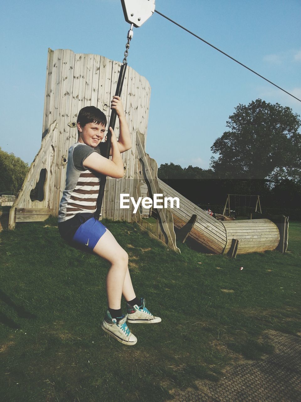 WOMAN STANDING ON SWING