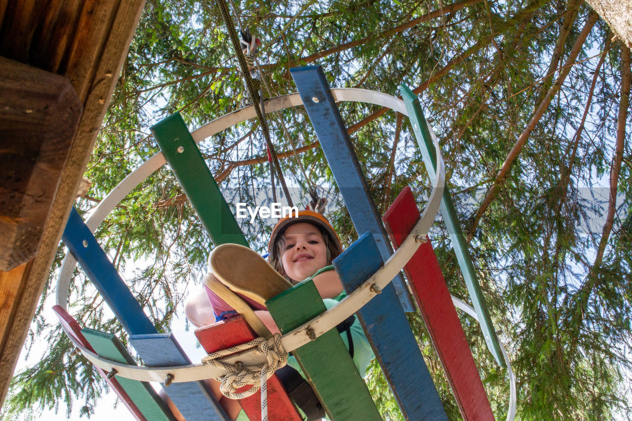 Adventure climbing high wire park - people on course in mountain helmet and safety equipment