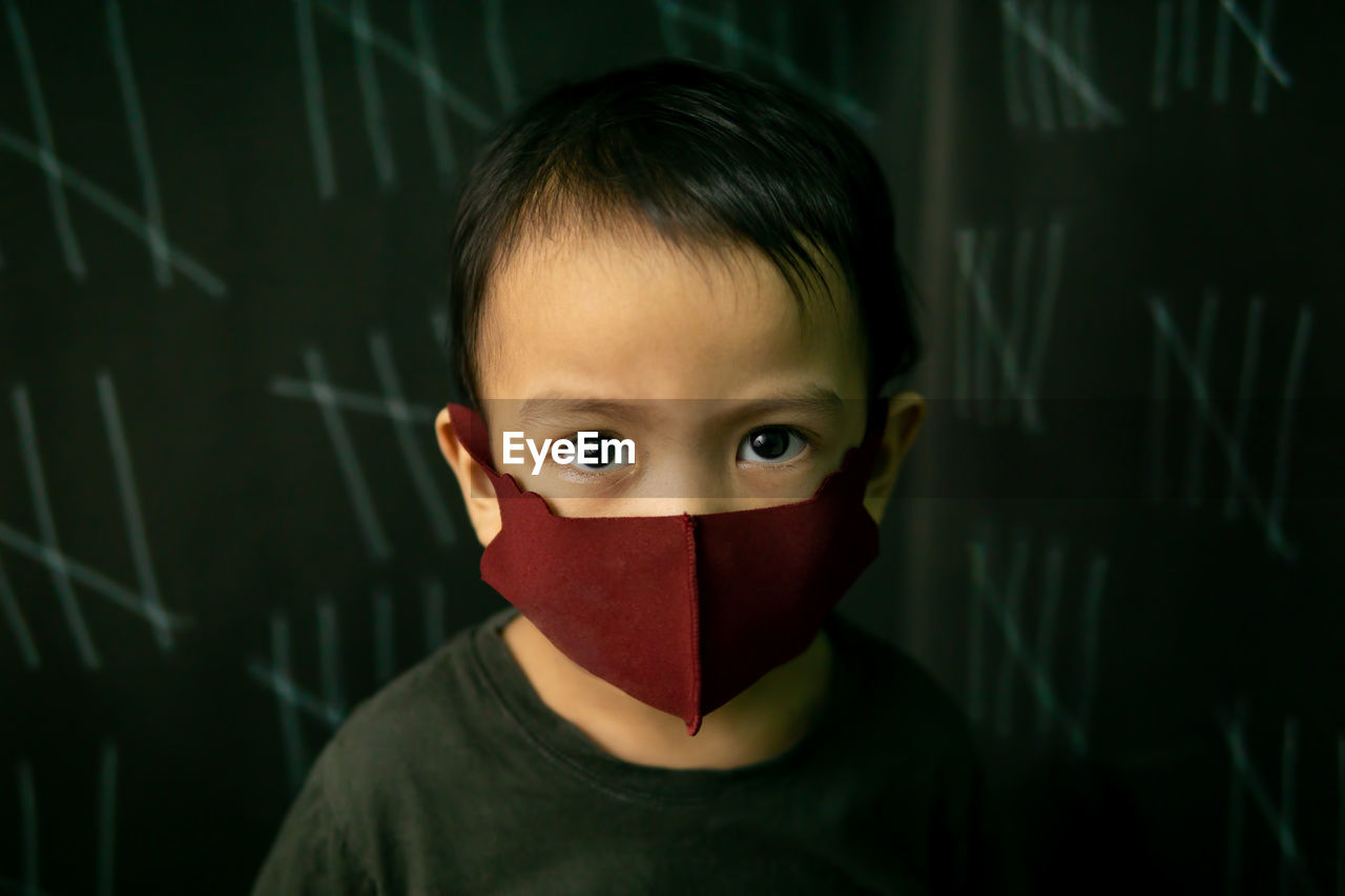 Close-up portrait of cute boy wearing mask