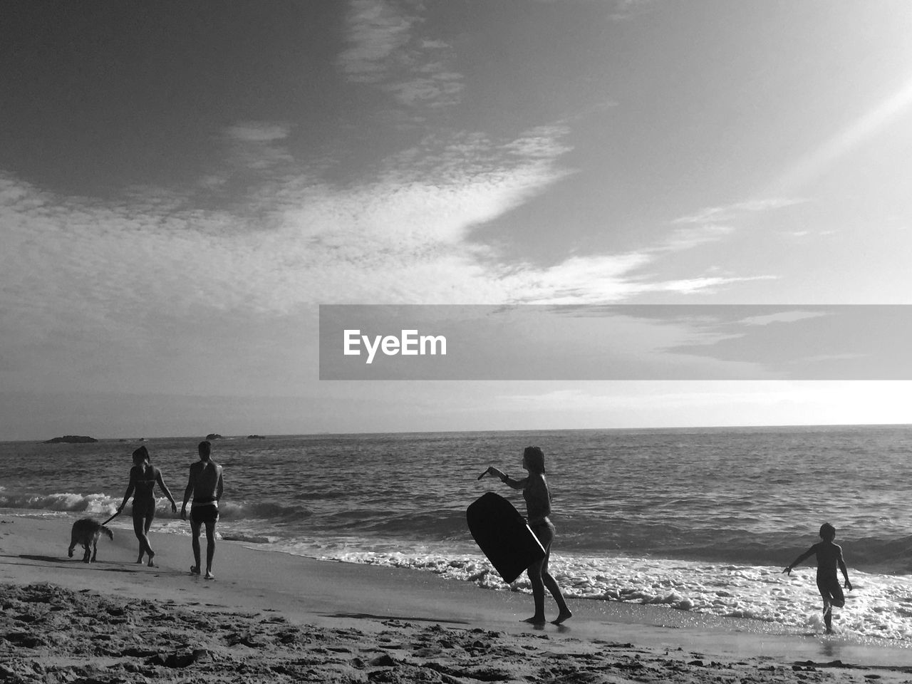 People enjoying at beach against sky