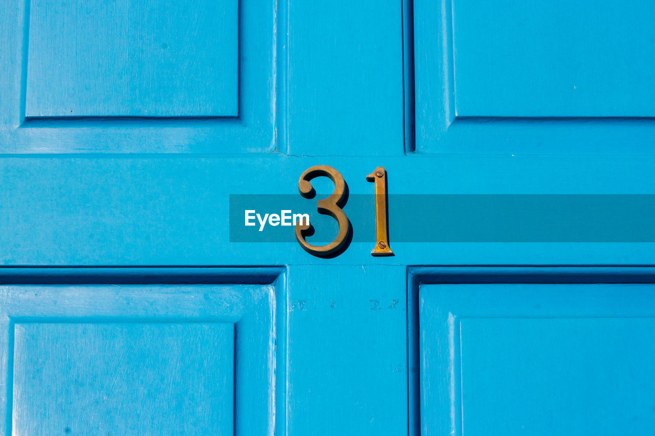 House number 31 on a blue wooden front door in london 