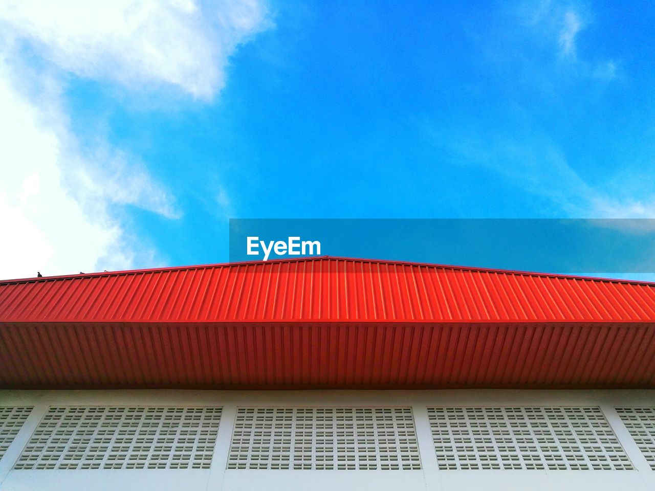 Low angle view of building against blue sky on sunny day