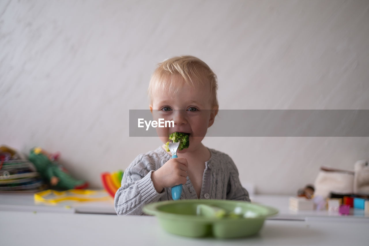 close-up of cute girl eating food on table
