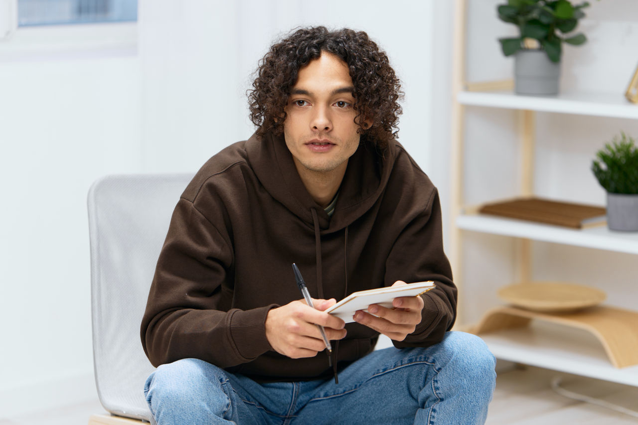 portrait of young woman using mobile phone while sitting at home