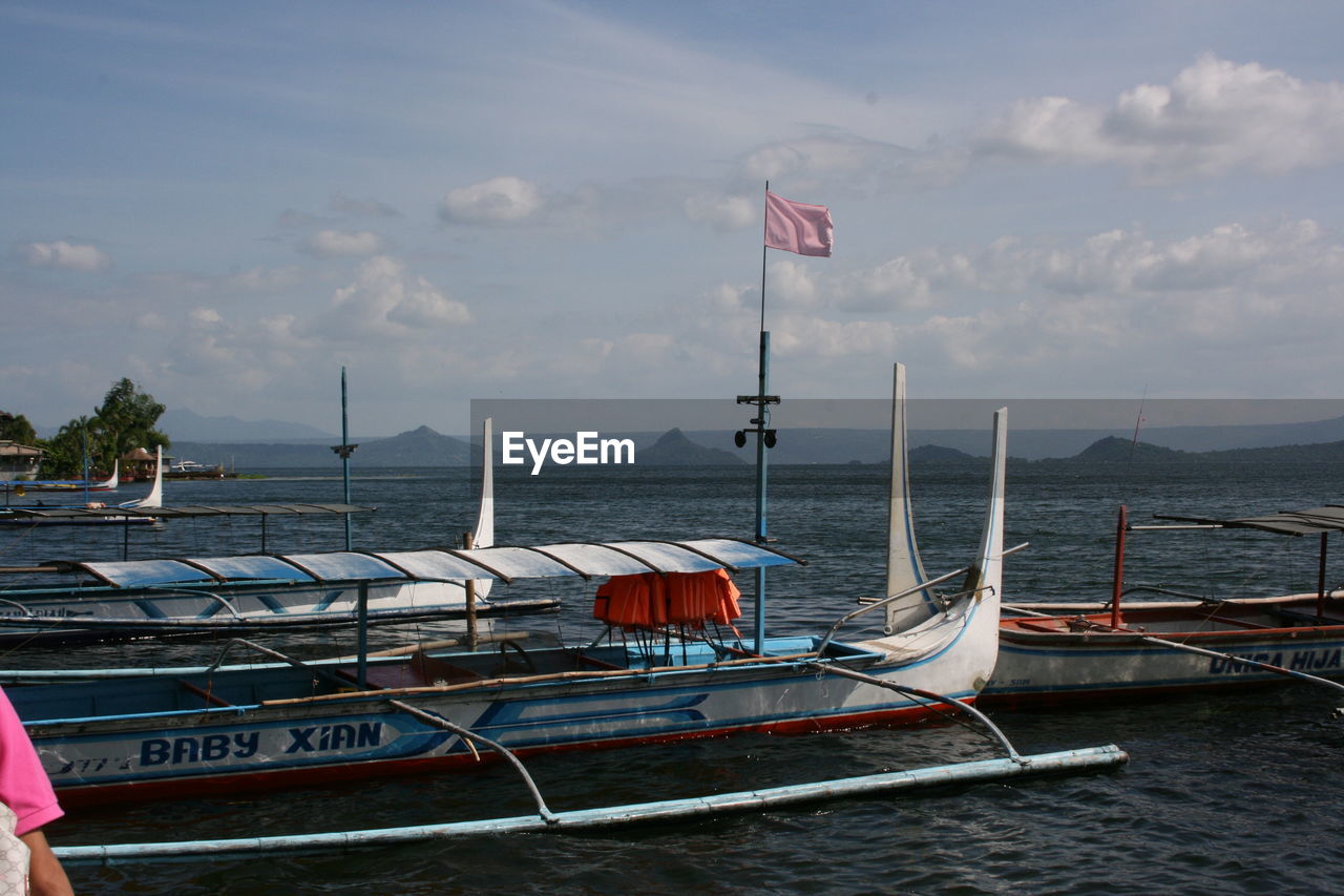 Boats moored on sea against sky