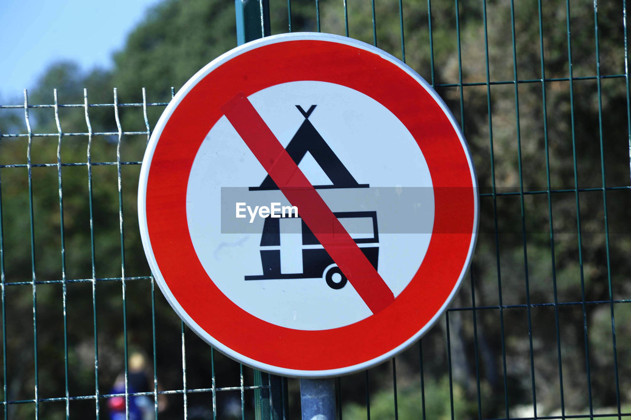 Close-up of warning sign on fence