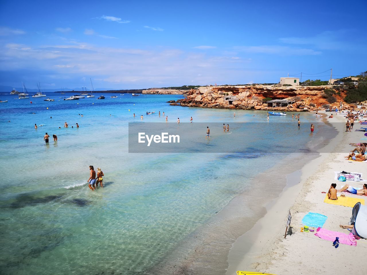 People enjoying at beach against sky