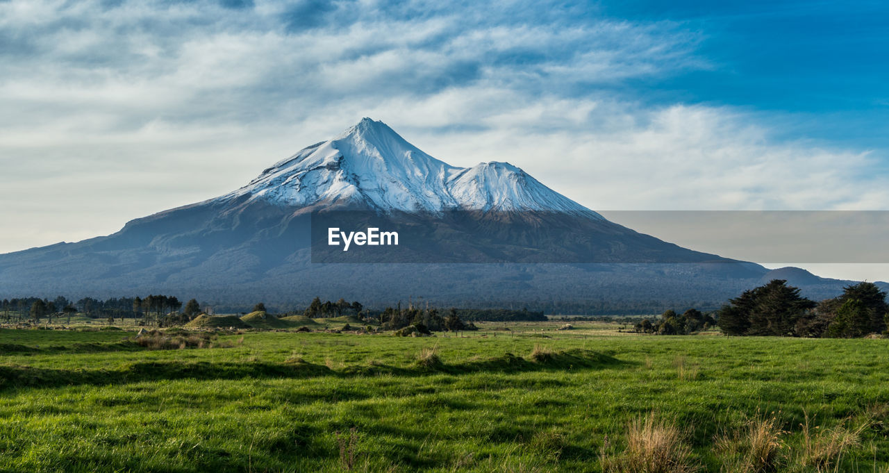 Scenic view of grassy landscape against mountain