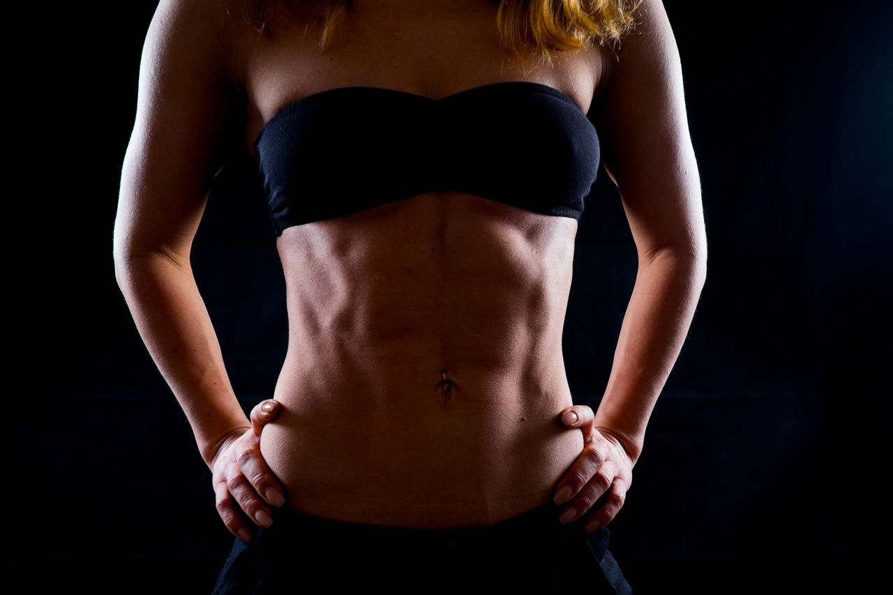 Woman standing against black background