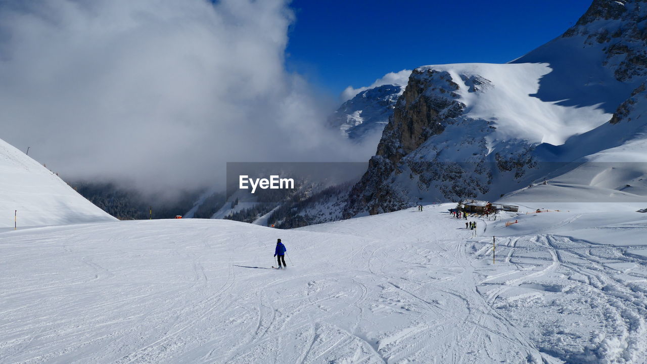 Person skiing on snowcapped mountain against sky