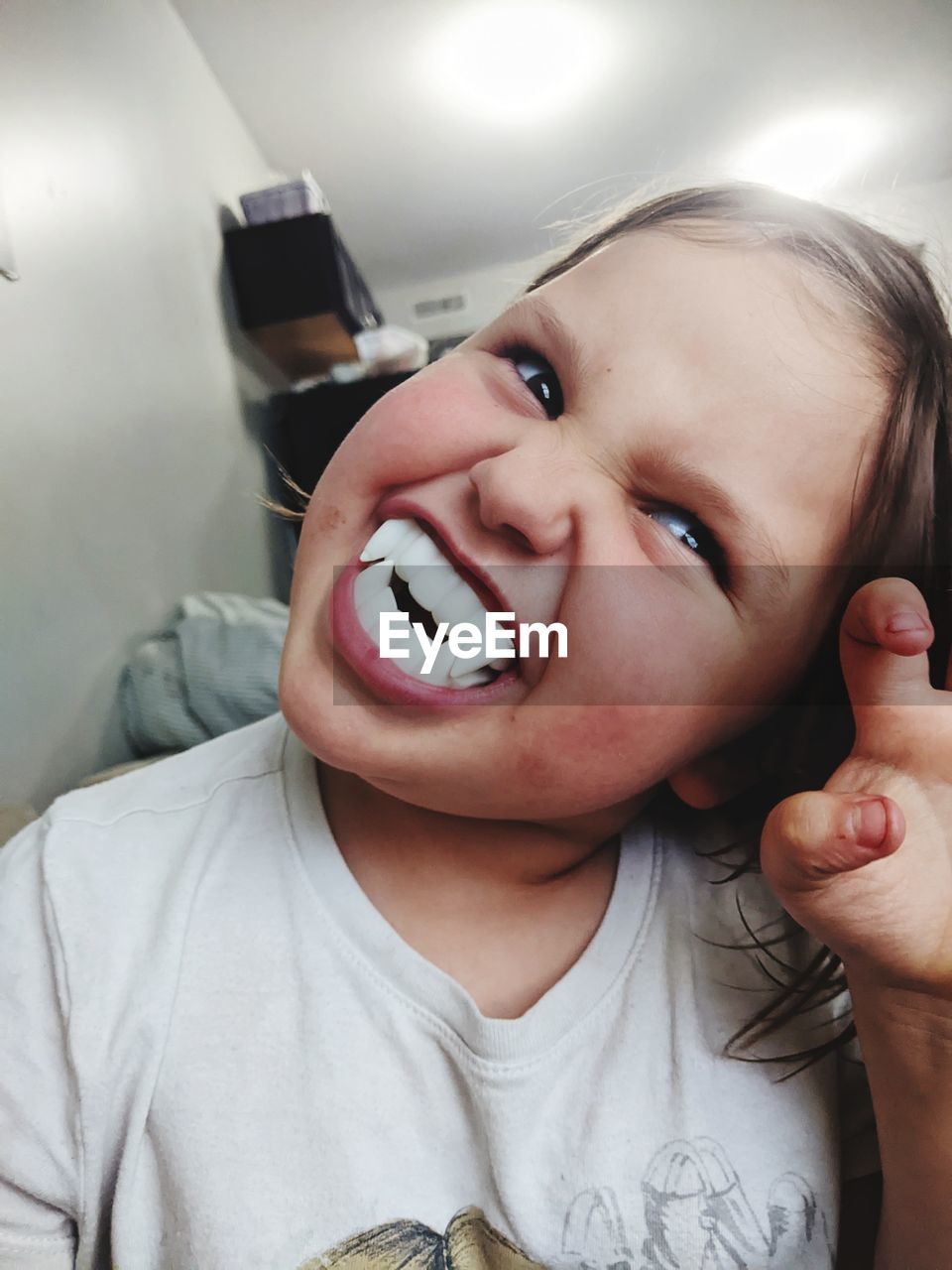 child, skin, childhood, baby, person, one person, portrait, human face, smiling, human head, indoors, human mouth, nose, emotion, mouth open, toddler, headshot, hand, human eye, front view, close-up, looking at camera, holding, facial expression, men, lifestyles, technology, communication, female, casual clothing, portrait photography, women, laughing