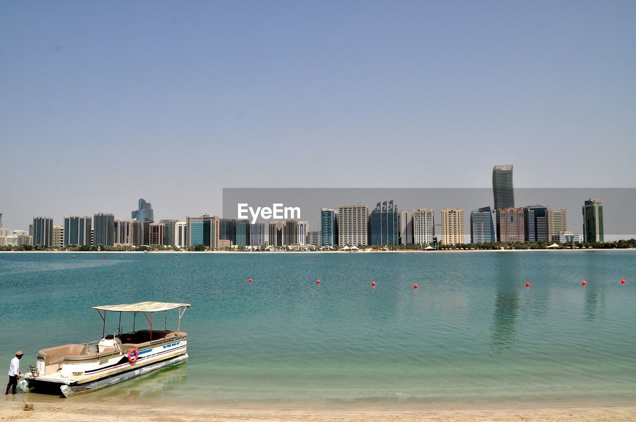 View of sea and buildings against clear sky