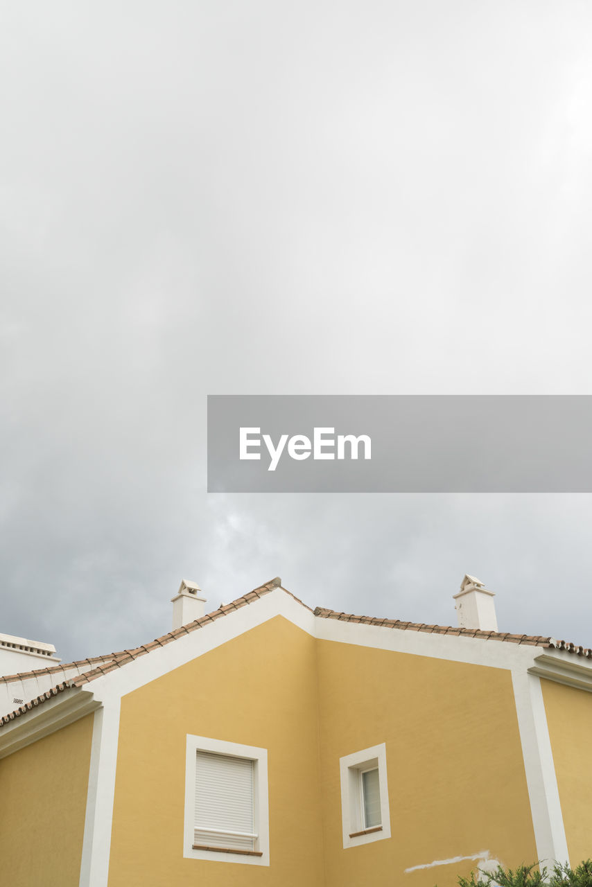 LOW ANGLE VIEW OF BUILDING AGAINST CLOUDY SKY