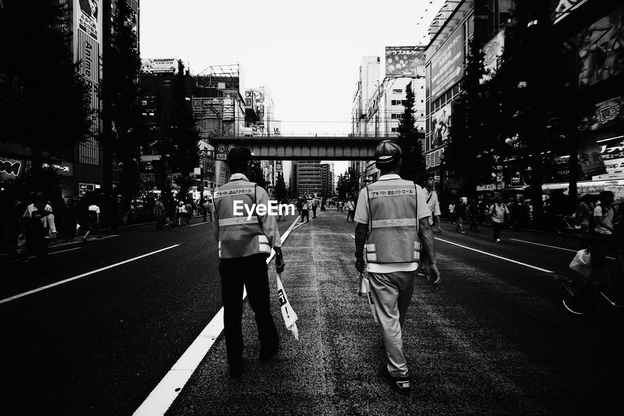 Rear view of construction workers walking on road