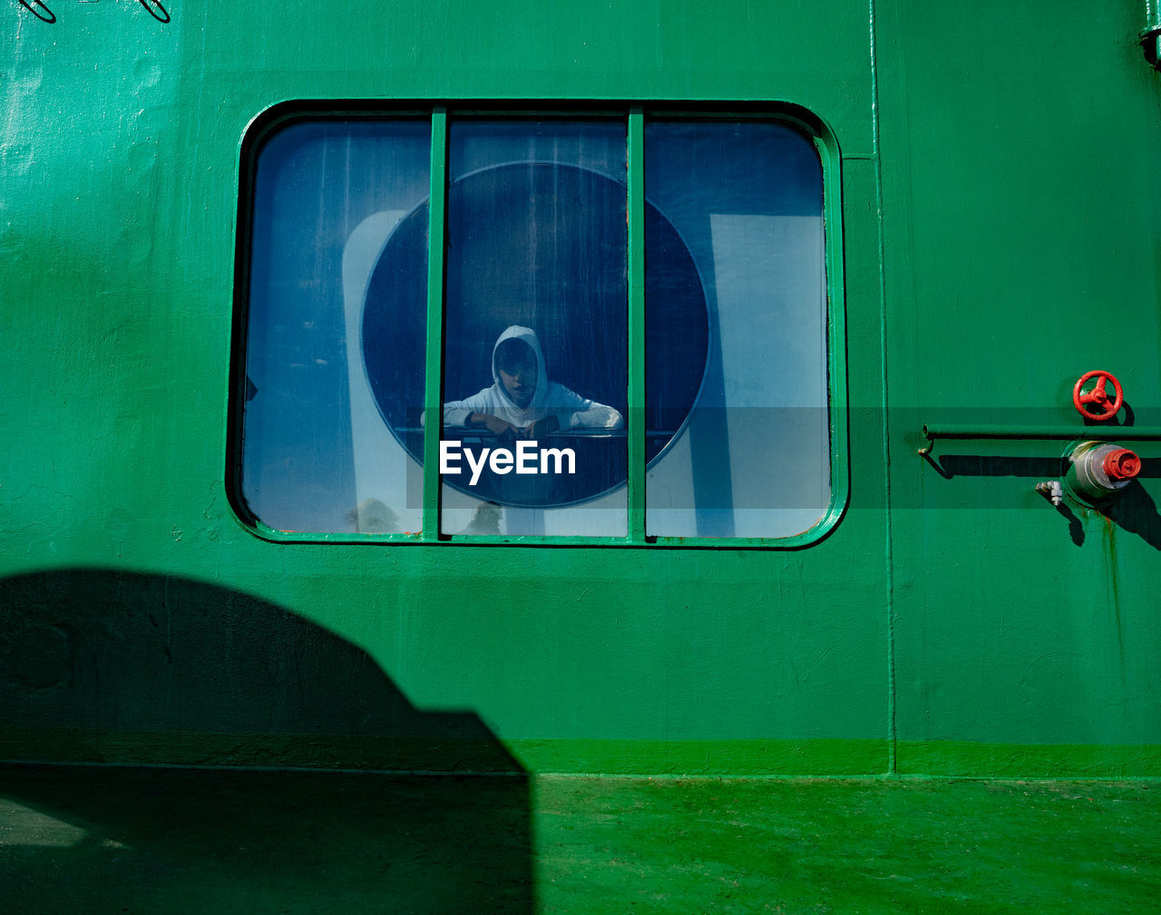 CLOSE-UP OF TRAIN WINDOW WITH CAR IN BACKGROUND