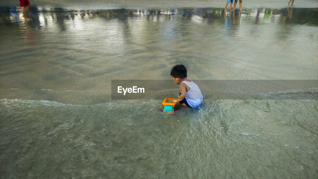 High angle view of boy playing at beach 